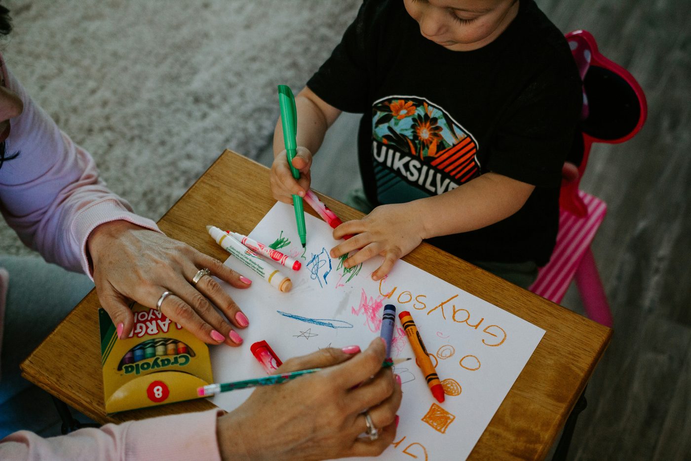 Parent and child coloring together at a table